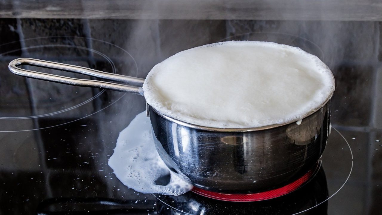 Casserole de lait qui déborde sur une plaque vitrocéramique radiante allumée